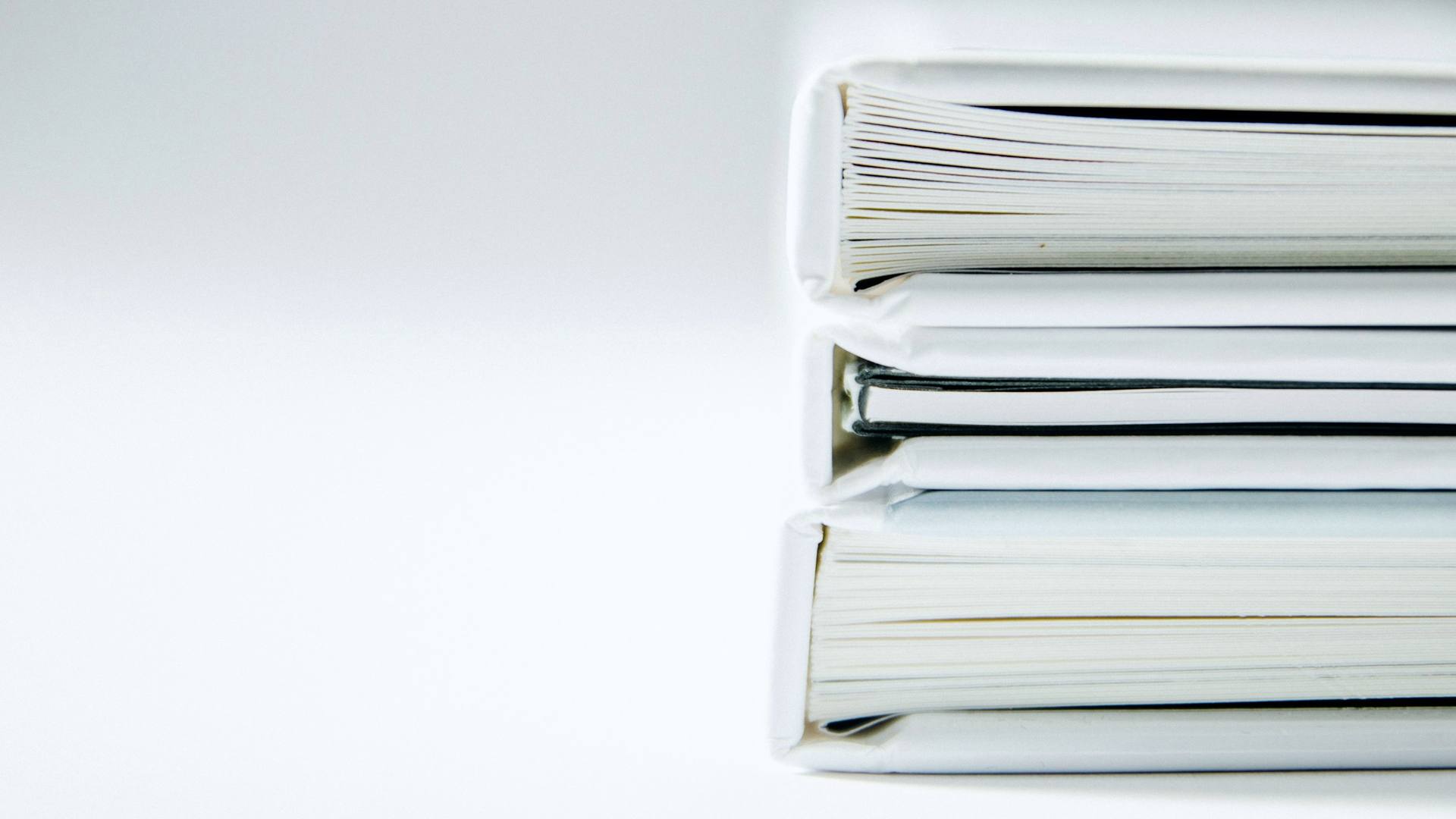 Pile de classeurs blancs sur un bureau clair